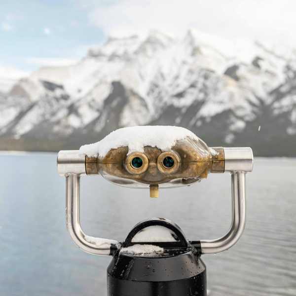 view of snow-covered mountains with binoculars in the foreground
