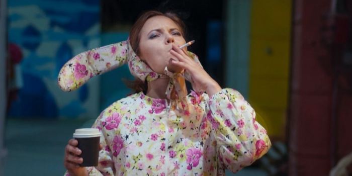 Tired out woman in a bunny suit smoking